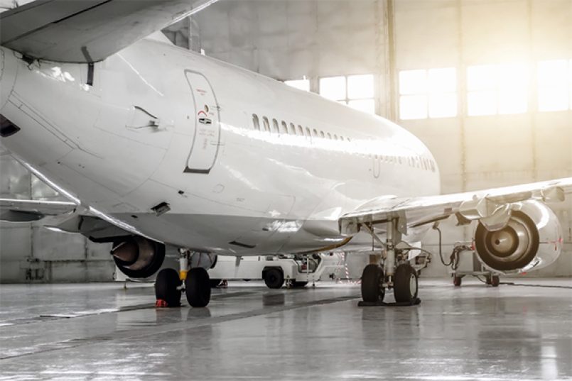 Ein weiß lackiertes Flugzeug in einem Hangar.