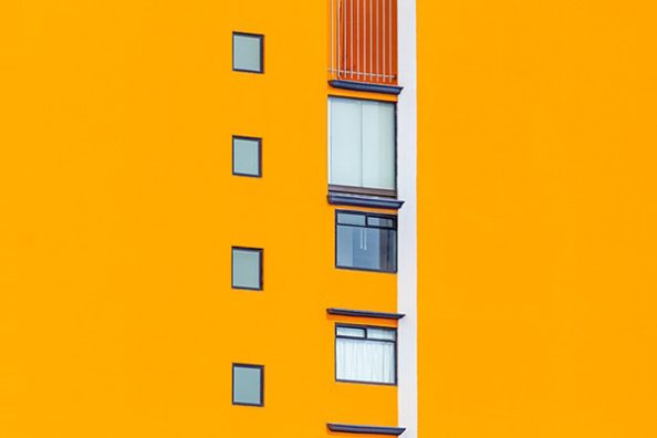 Eine gelb-orange gestrichene Fassade als Symbolbild.