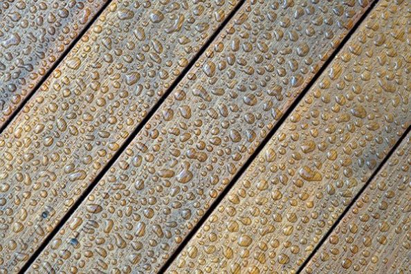 Holzbohlen mit Wassertropfen.