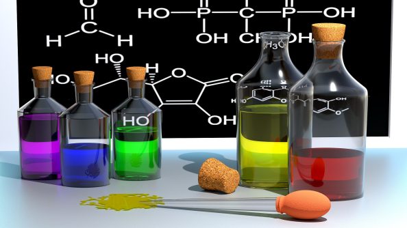 Reagenzgläser mit bunten Flüssigkeiten und eine Pipette.