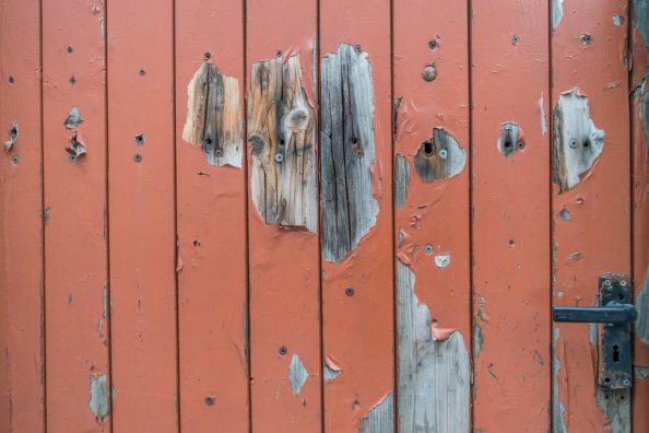 Abgeblätterte Farbe auf einer Holztür.